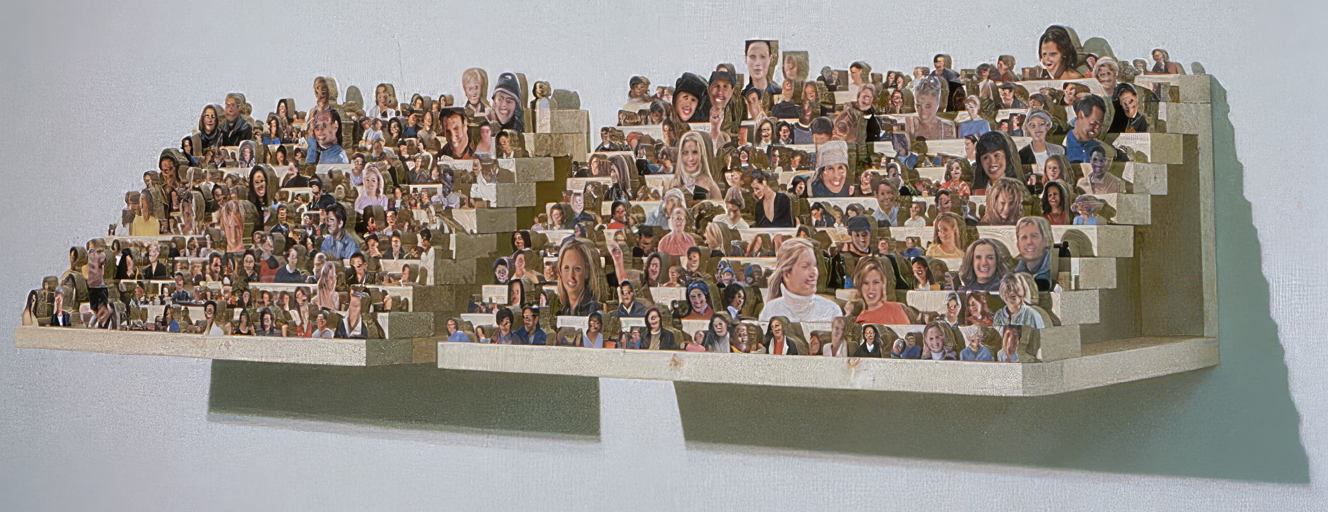 Rows of cut-out photographic portraits stand on a tiered, wall-mounted stadium structure.